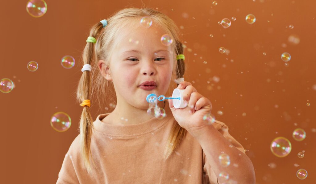 A photo of a young girl blowing bubbles.