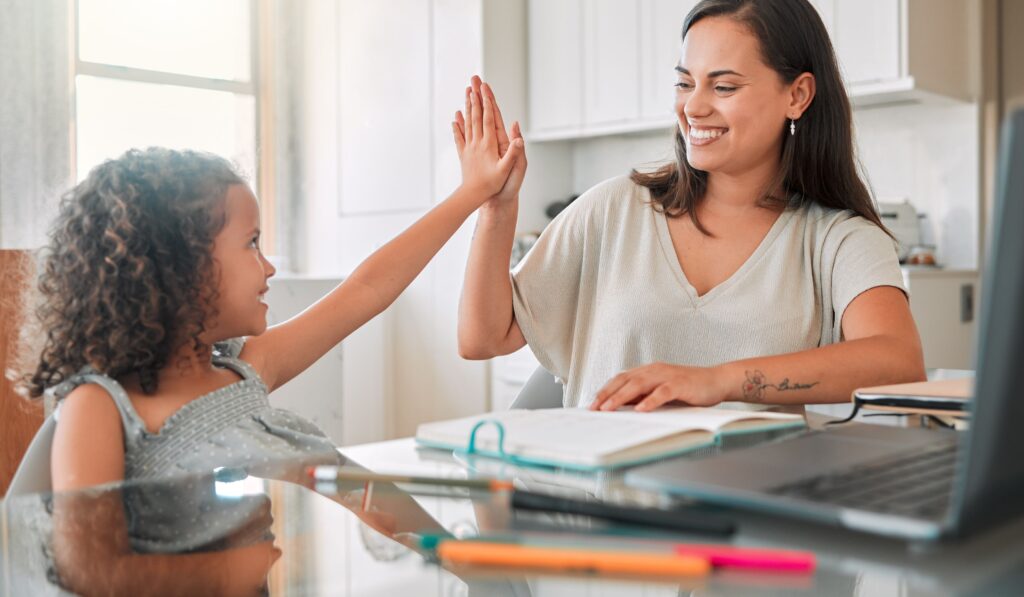 Images shows a speech therapist giving a student a high five