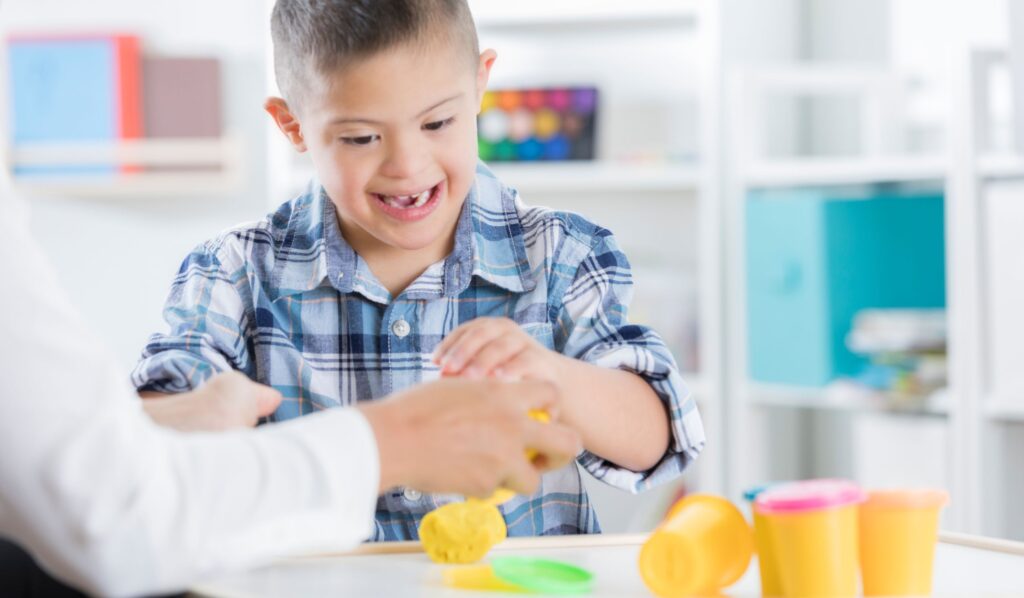 Image shows a young boy playing with playdough