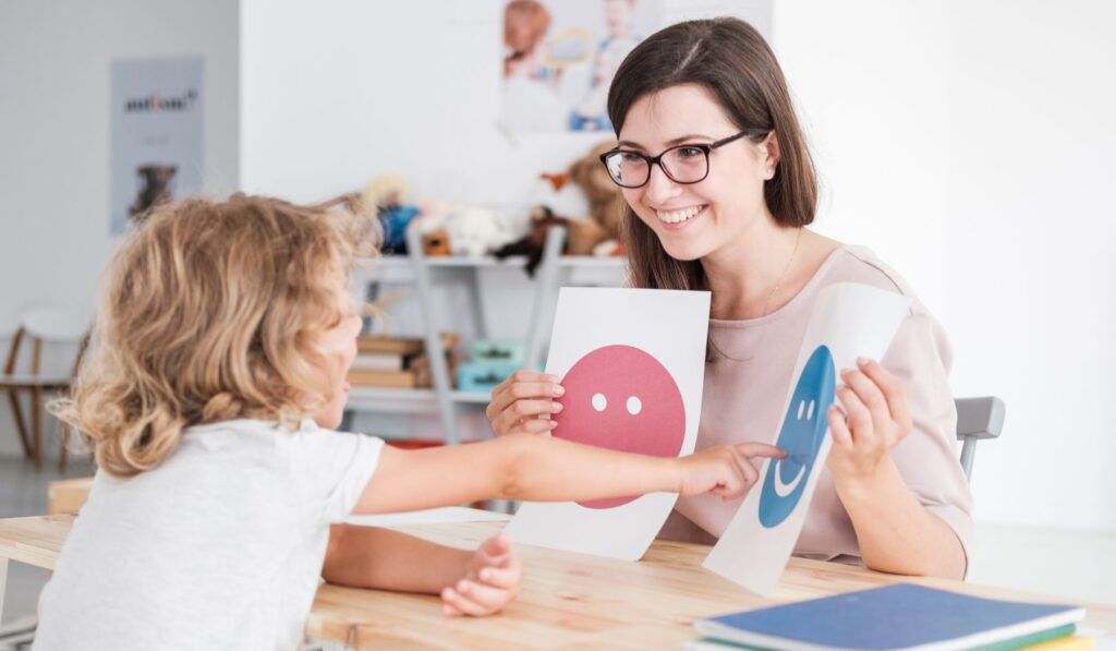 A teacher holding up two visual choices for a student